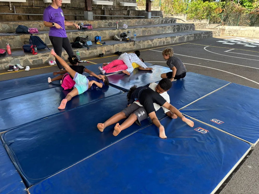 Élèves faisant des exercices au sol sur des tapis de gymnastique